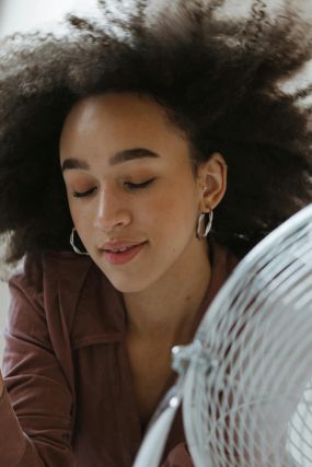 person keeping cool with fan